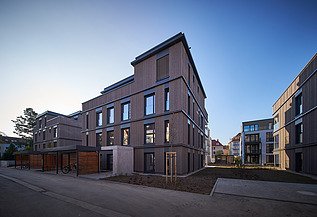 Photo of a multi-storey residential building with a wooden façade.