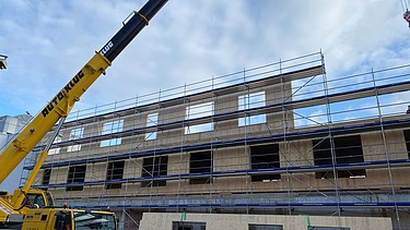 Photo of the assembly of the LENO cross-laminated timber elements. You can see large wooden elements.
