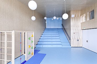 Foto des Flurbereichs des Kindergarten Ebersberg. Man sieht viele Holzoberflächen an Wänden und Decken.
