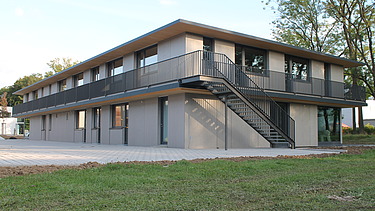 Foto der Anwaltskanzlei FGS Augsburg. Modernes Holzgebäude mit Flachdach.