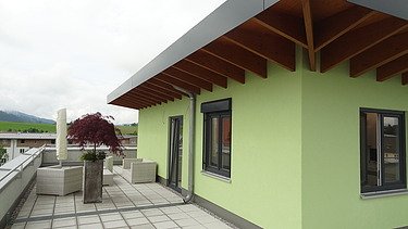 Foto eines Eckdetails eines Gebäudes mit grüner Fassade.
