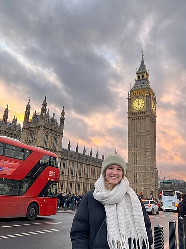 Photo of a young woman in London. Big Ben can be seen in the background.