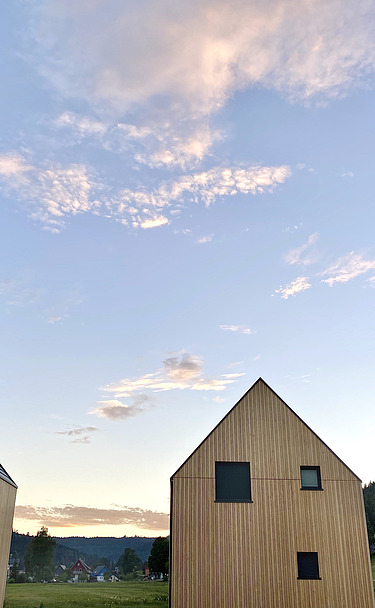 Chalets Engel Baiersbronn Foto des möblierten Wohnraums des Chalets Engel in Baiersbronn. Zu sehen sind drei Gebäude aus Holz.