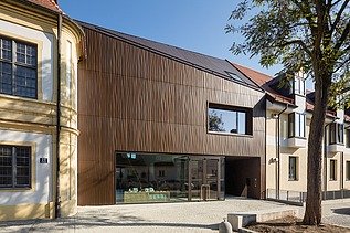 Foto eines Gebäudes aus Holz mit brauner Fassade.
