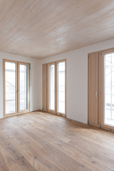 Foto eines leeren Wohnraumes, des Holzgebäudes CARL in Pforzheim. Man sieht viele Holzoberflächen.