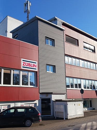 Foto eines Gebäudes mit roter Fassade. Standort ZÜBLIN Timber Gaildorf.