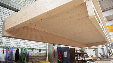 Foto eine schwebenden Rippenelements am Kran in der Produktionshalle von ZÜBLIN Timber.