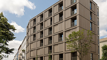 Photo of the multi-storey residential complex in Stendaler Strasse Berlin. You can see a tall building with a wooden façade.