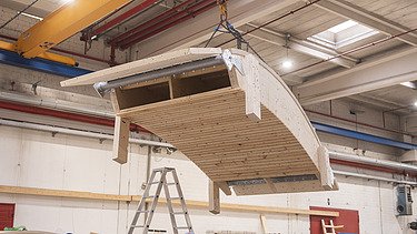 Photo of a production hall with a curved wooden shell on the crane