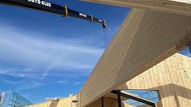 Photo of the assembly of the LENO cross-laminated timber elements. You can see large wooden elements.