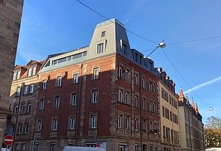 Aufstockung Nürnberg Foto einer Aufstockung aus Holz. Man sieht mehrere, hohe Gebäude.