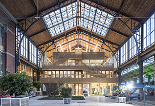 Photo of the hall of the Gare Maritime Brussels. Huge, open hall space with wooden roof construction.