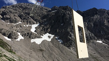 Foto der Holzbaumontage des Waltenberger Haus in Oberstdorf. Helikopter-Montage eines schwebenden LENO-BSP-Elements.