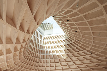 Foto von einer Holzstruktur bzw. einer Holzdecke mit einem Fensterloch in der Mitte