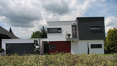 Foto eines kubischen Wohnhauses aus Holz mit Putzfassade. LENO-BSP.