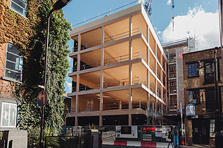 Photo of the shell of the multi-storey Black and White office building in London. You can see a building structure made of wood.