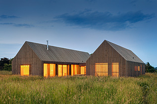 Photo of a modern wooden house in U-shape with wooden facade. LENO-BSP.