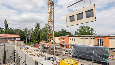 Foto der Montage eines LENO-ADD-Holzelements auf der Baustelle der Schule in Erfurt.