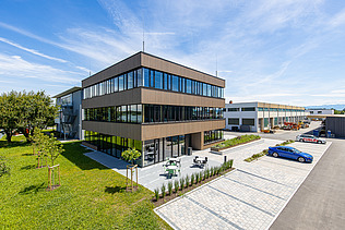 Foto eines Holzgebäudes mit Holz-Glasfassade und Flachdach.