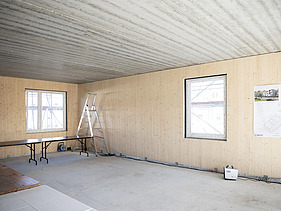 Photo of a building shell. You can see the wooden walls. 