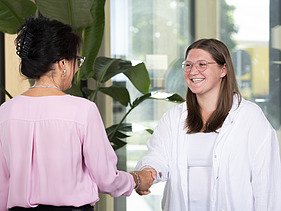 Foto von zwei Frauen, die sich die Hand geben. Ausbildung Industriekauffrau:man.