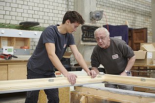 Sebastian works with an experienced carpenter.