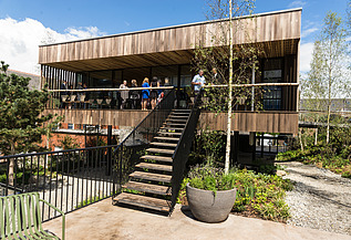 Foto von eines Holzgebäudes mit Flachdach und großer Treppe.