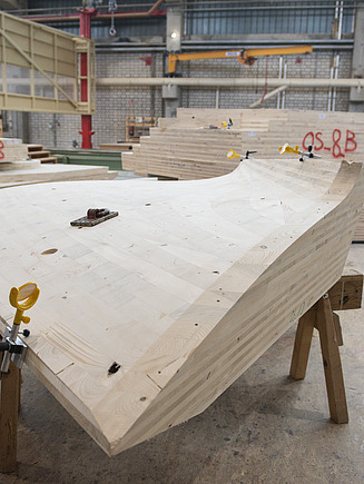 Foto eines 3D-gekrümmten LENO-Brettsperrholzelements. Es liegt in der Produktionshalle von ZÜBLIN Timber.