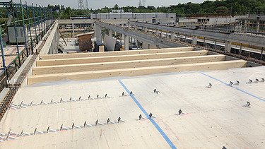 Foto der Montage von Deckenelementen aus Holz. Projekt Bürogebäude Flexim Berlin