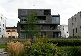 Photo of a multi-storey residential building with a wooden façade.