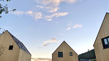 Foto des möblierten Wohnraums des Chalets Engel in Baiersbronn. Zu sehen sind drei Gebäude aus Holz.