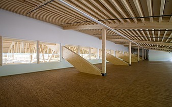 Foto der Montagehalle Pilatus CH-Stans. Zu sehen ist eine Brettschichtholz-Dachkonstruktion.