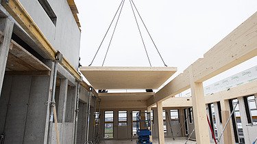 Photo of the installation of a LENO ceiling element in the new ZÜBLIN Timber office building in Aichach.