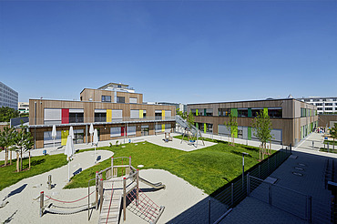 Elementary school Munich Photo of a wooden school from the outside. You can see the wooden building and the garden area.