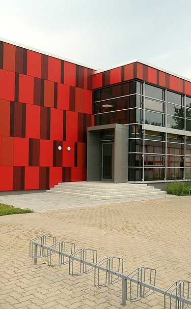 Foto einer Außenansicht der Einhardschule in Seligenstadt. Man sieht eine rote Fassade.