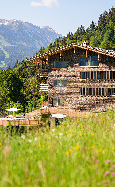 Foto ein Hotels aus Holz in Mitten der Berglandschaft.