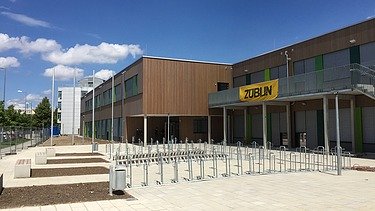 Photo of the entrance area of a school. You can see part of the wooden building.