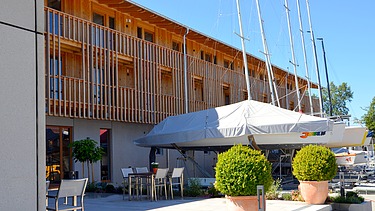Photo of the yacht club clubhouse in Prien am Chiemsee. You can see a modern wooden building.