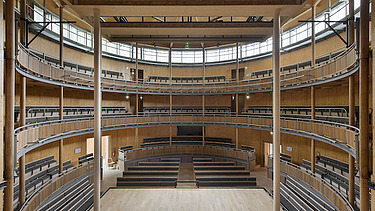 Photo of the Elizabethan Theater in Condette France. You can see a round interior with many wooden surfaces.
