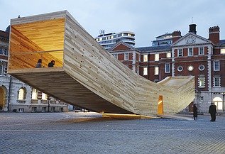 The Smile - Sculpture Design Festival London Photo of the curved wooden sculpture The Smile in London. The wooden box can be walked on and is intended to represent a smiling mouth.