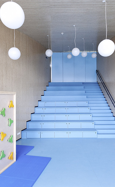 Foto des Flurbereichs des Kindergarten Ebersberg. Man sieht viele Holzoberflächen an Wänden und Decken.