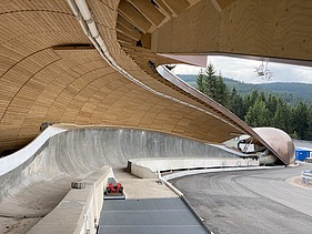 Foto einer Rodelbahn. Man sieht eine Holzüberdachung und nur einen Ausschnitt davon