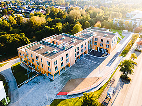 Photo of Witten University from the outside. You can see a large wooden building from a bird's eye view.