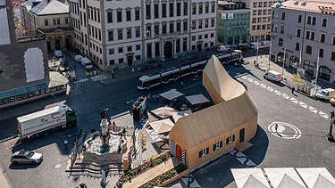 Luftaufnahme des geschwungenen Holzpavillons NEXT500 der Fuggerei Augsburg.