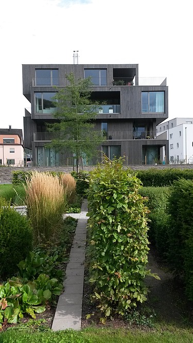 Photo of a multi-storey residential building with a wooden façade.
