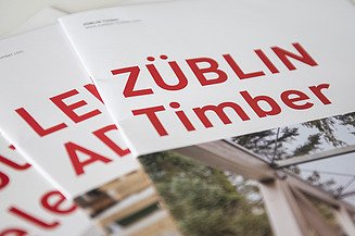 Downloads Photo of several brochure covers with red lettering. ZÜBLIN Timber.