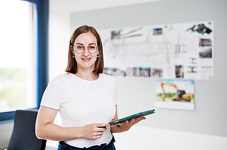 Karriere Ausbildung Bauzeichner:in bei ZÜBLIN Timber Foto einer jungen Auszubildenden, stehend am Bildschirmarbeitsplatz. Ausbildung Bauzeichnerin.
