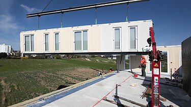 Foto der Montage von LENO-ADD-Holzbauelementen, auf der Baustelle Quartier Hangweide in Kernen