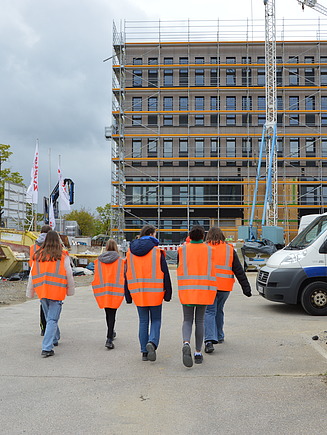 Photo of several young girls at Girls Day in Aichach. They are walking to the new T3 office building.