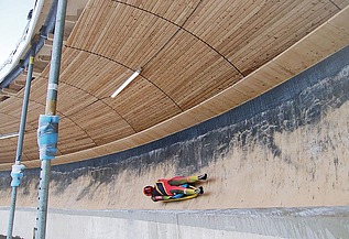Photo of a toboggan run with wooden roofing and a reclining bobsledder